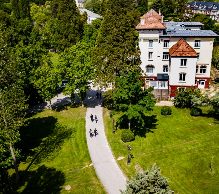 Vue aérienne de l'École des Roches, un bâtiment ancien sur plusieurs niveaux avec un chemin pour y accéder