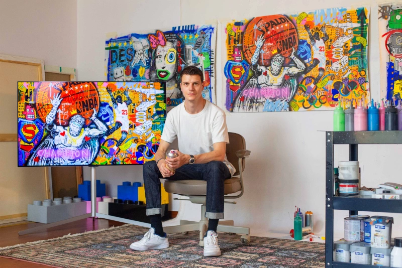 Jisbar posant devant ses oeuvres